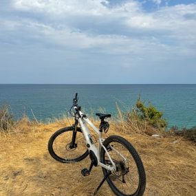 Ηλεκτρικό ποδήλατο με φόντο το Αιγαίο, σε παραθαλάσσιο σημείο του Ολύμπου