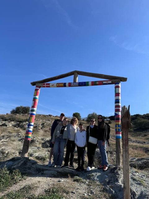 International Group – Olympus Trail Experience Ομάδα επισκεπτών κάτω από πολύχρωμη κατασκευή με σημαίες στον Όλυμπο – πεζοπορική και πολιτιστική δραστηριότητα
